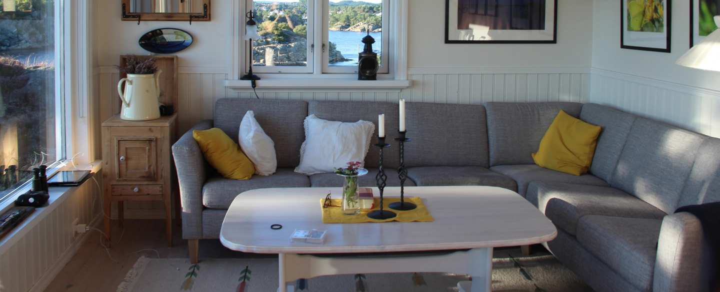 beige wall colored living room with a grey sofa with yellow and white pillows