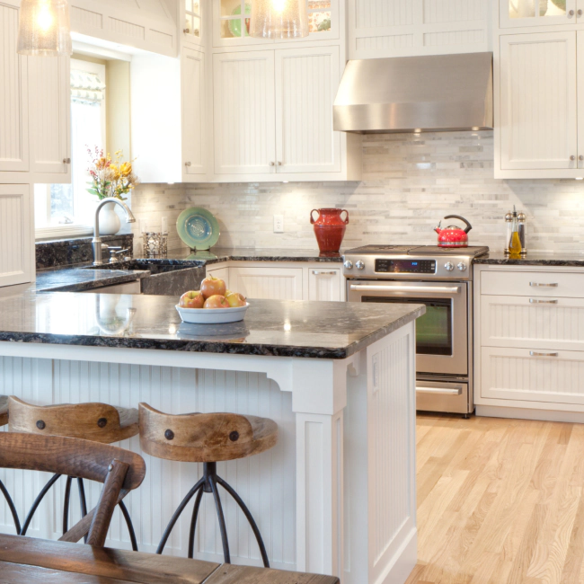 white and beige kitchen with white cabinets and a black countertop