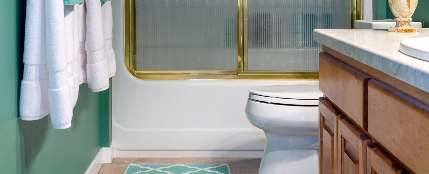 white and green bathroom with brown cabinets and a white wc